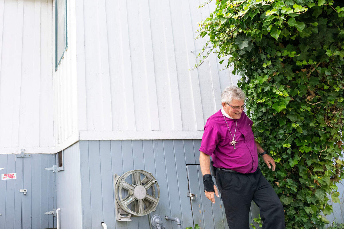 Rt. Rev. Morgan Johnson takes a step away from the century-old ivy plant that stands alongside the 150-year-old church he serves on Thursday, Aug. 10, 2023, in Tacoma. Johnson has been serving at St. Peter’s Church in the Old Town district of Tacoma and is preparing the church to celebrate its 150th anniversary. Rev. Johnson says it was the first church in Tacoma and possibly one of the longest standing buildings in Old Town.