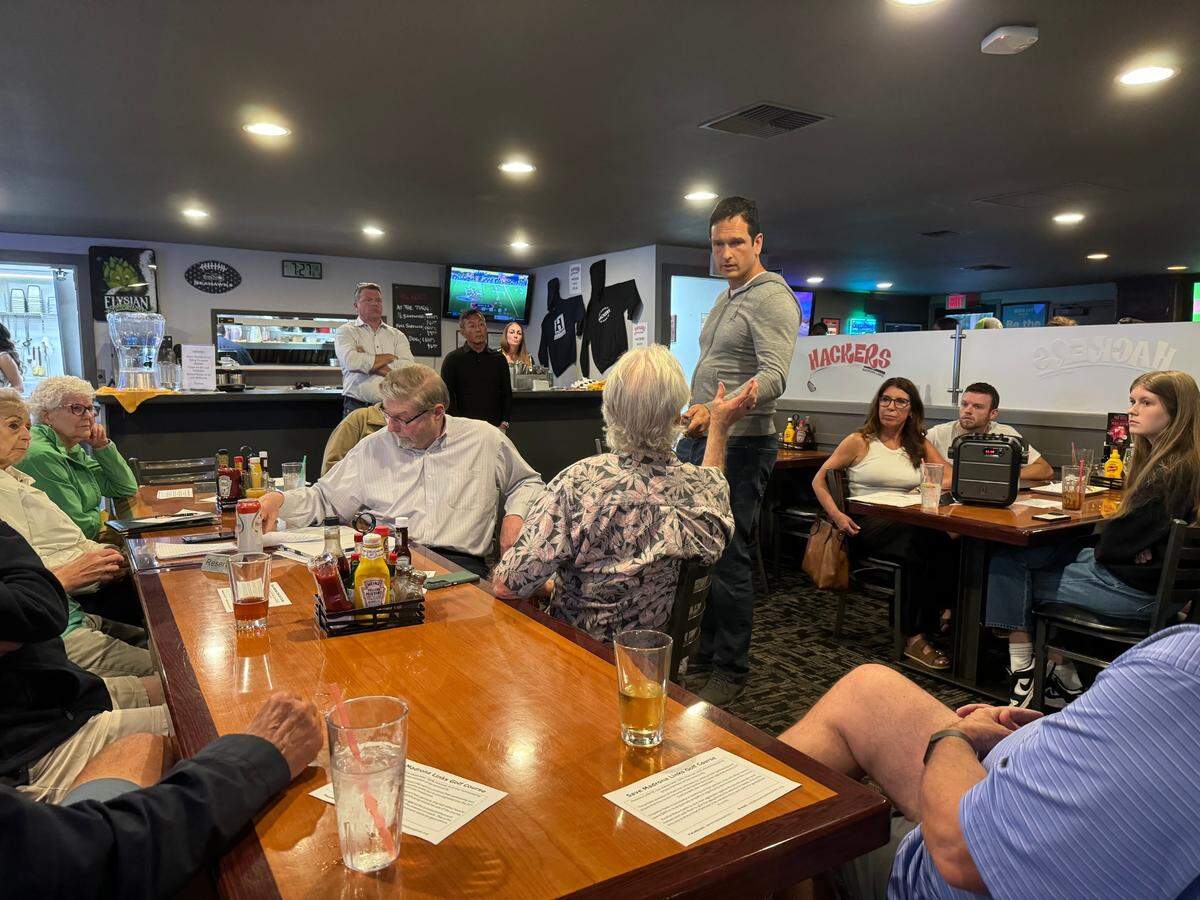 Ezra Eickmeyer, a spokesperson for ZTM Holdings, answers questions from golfers about plans for Madrona Links at a public meeting hosted at Hackers Bar & Grill on Tuesday, Aug. 13, 2024.