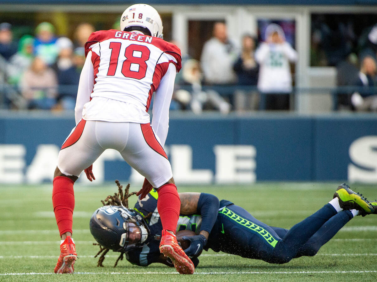Seattle Seahawks cornerback Sidney Jones (23) nearly intercepts a pass by Arizona Cardinals quarterback Colt McCoy (12) intended for wide receiver A.J. Green (18) during the third quarter of an NFL game on Sunday afternoon at Lumen Field in Seattle. The call was later overturned and Arizona retained possession of the ball.