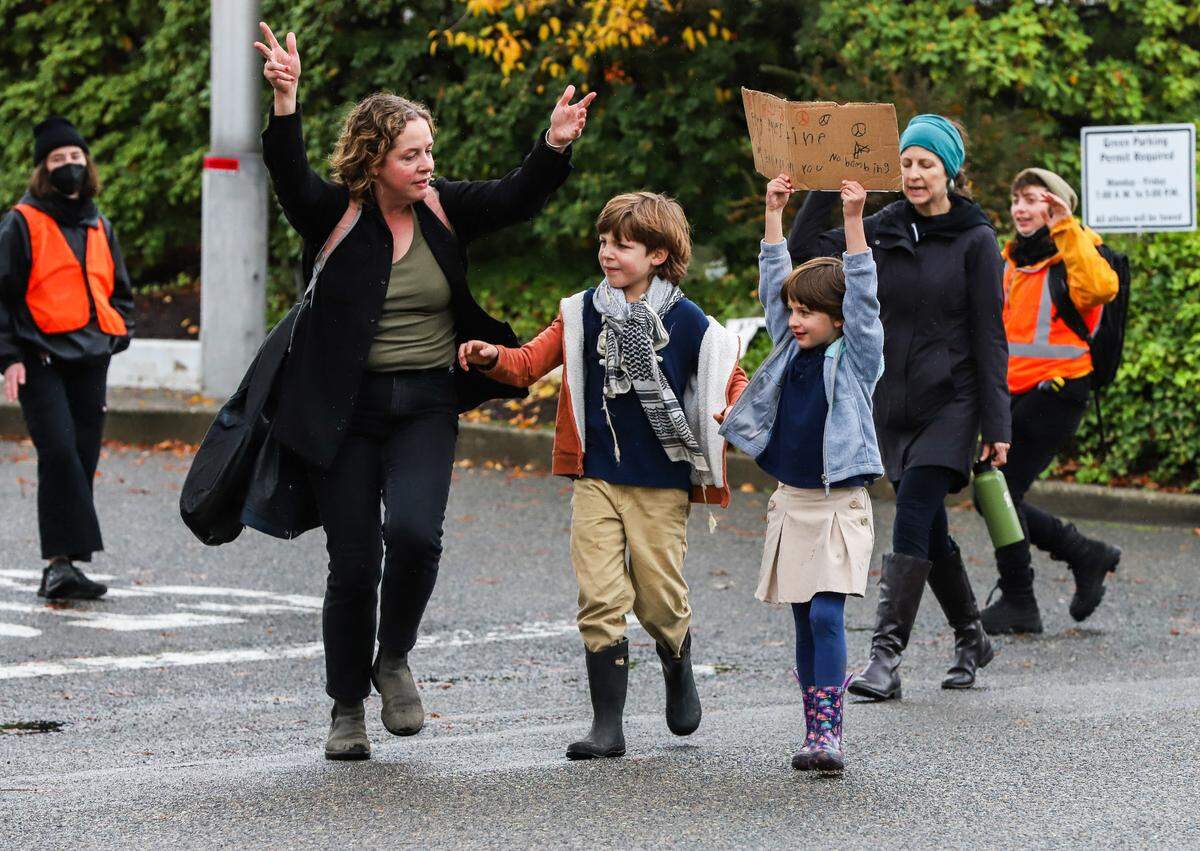 A woman and two kids join the protest at the Port of Tacoma where protesters gathered to protest the arrival of MV Cape Orlando on Monday, November 6, 2023.