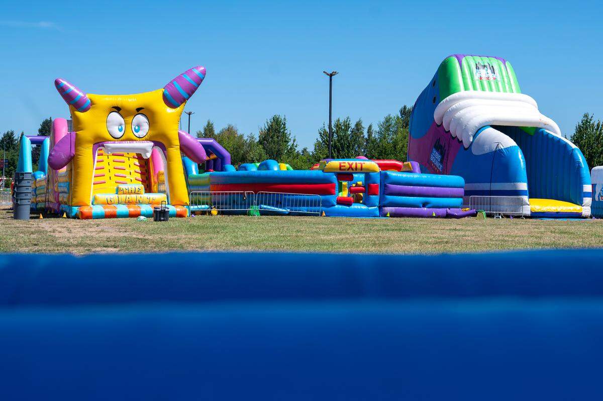 Additional bounce houses, including the Air Space, The Giant, left, Sport Slam and City Escape are blown up in anticipation of weekend visitors at The Big Bounce America tour on Friday, July 11, 2025, at the Puyallup fairgrounds in Puyallup, Wash.