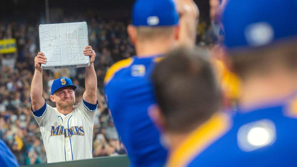Fighting back tears as teammates and fans applaud, Seattle’s Kyle Seager holds up the third base bag which was pulled for him by a groundskeeper. Seager played the position his entire career and Sunday’s season finale on Oct. 3, 2021, may likely be his last in a Mariners uniform.