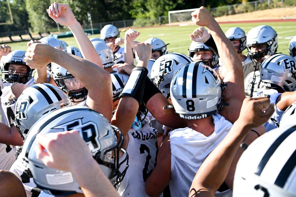 Student-athletes huddles during a football practice at Emerald Ridge High School, Wednesday, Aug. 16, 2023, in Puyallup, Wash.