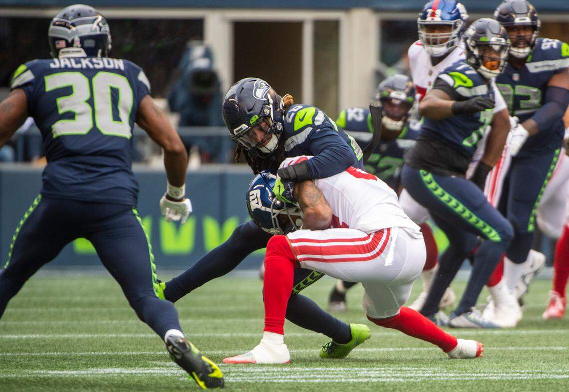 Seattle Seahawks safety Ryan Neal (26) tackles New York Giants wide receiver Marcus Johnson (84) in the first quarter of an NFL game at Lumen Field in Seattle, Wash. on Oct. 30, 2022. The Seahawks defeated the Giants 27-13.