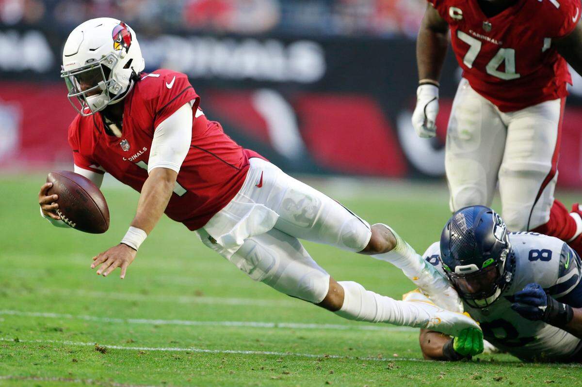 Arizona Cardinals quarterback Kyler Murray (1) is sacked by Seattle Seahawks defensive end Carlos Dunlap (8) during the first half of an NFL football game Sunday, Jan. 9, 2022, in Glendale, Ariz. (AP Photo/Ralph Freso)