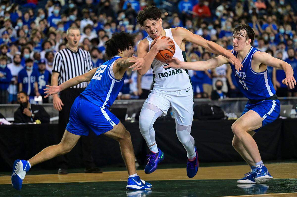 Auburn guard Maleek Arington (3) drives to the basket between Seattle Prep guard Braeden Smith (22) and guard Dyllan Hoffman (11) during the fourth quarter of a Class 3A semifinal state tournament game on Friday, March 4, 2022, at the Tacoma Dome, in Tacoma, Wash.