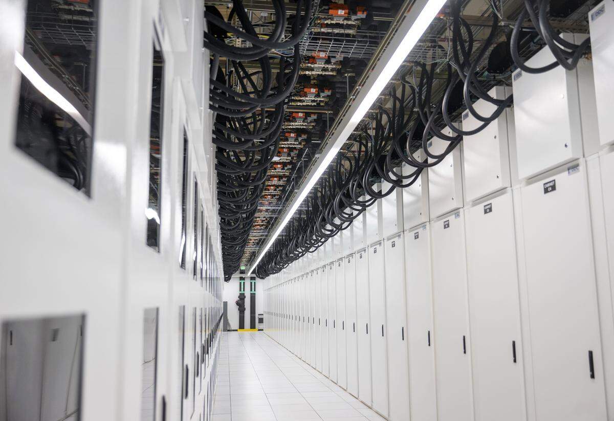 Rows of high-powered servers are stored in white cabinets on Friday, Feb. 13, 2026, at the Centeris SH1 Data Center in Puyallup, Wash. Liquid cooling is used to maintain temperatures in the cabinets through the attached black hoses.