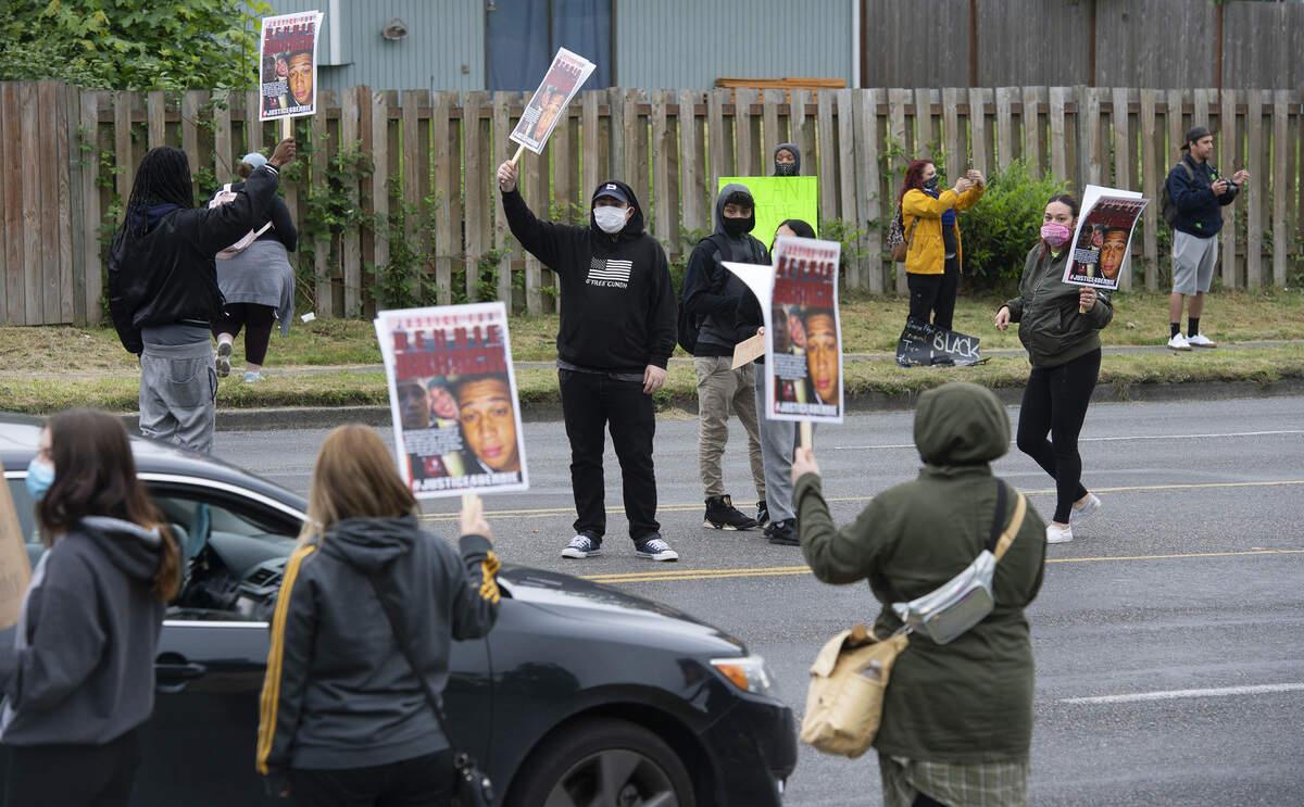 Protesters carry signs along 72nd Street during a Black Lives Matter rally and march at Wapato Park in east Tacoma on Tuesday, June 2, 2020.