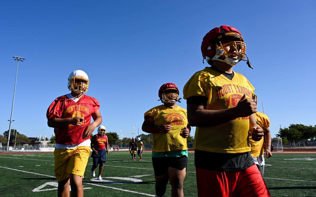 Student-athletes come off the field for water during practice at Mount Tahoma High School, Friday, Aug. 18, 2023, in Tacoma, Wash.