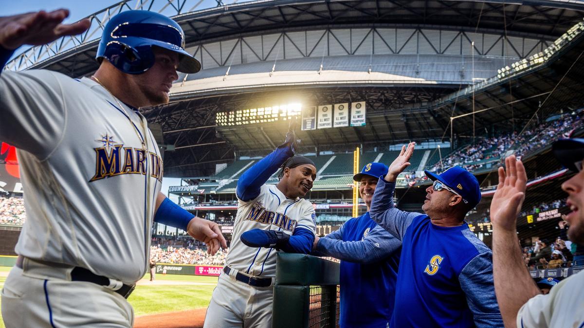 Daniel Vogelbach, left, and Mallex Smith, right celebrate with coaches after scoring on a Mitch Haniger double in the third inning. The Seattle Mariners played the Boston Red Sox in a Major League Baseball Game at T-Mobile Park in Seattle, Wash., on Sunday, March 31, 2019.