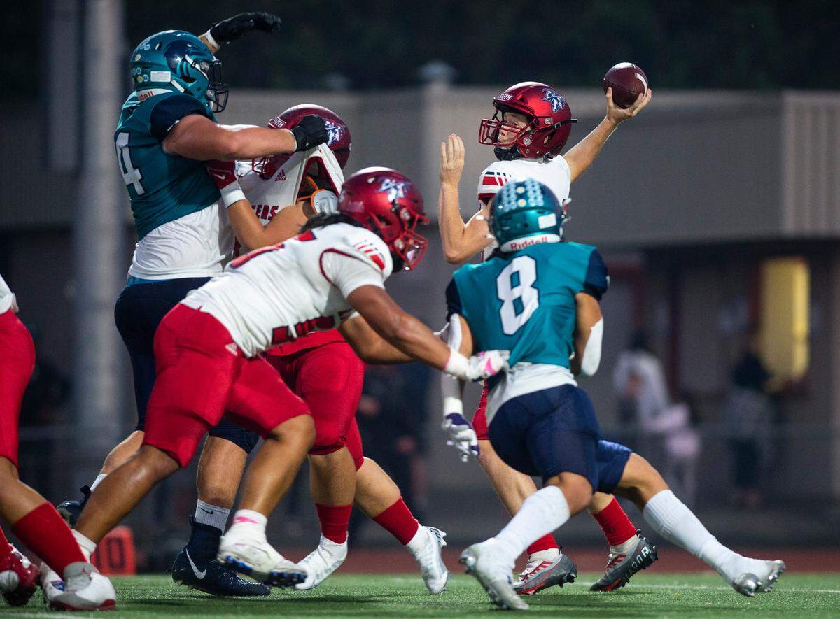 Kennedy Catholic quarterback Payton Faker (15) looks to pass the ball but as he throws it Auburn Riverside defensive lineman Nathan Pritchard (74) blocks the pass in the second quarter of a game at Auburn Memorial Stadium in Auburn, Wash. on Oct. 6, 2022. Kennedy Catholic defeated Auburn Riverside 47-17.