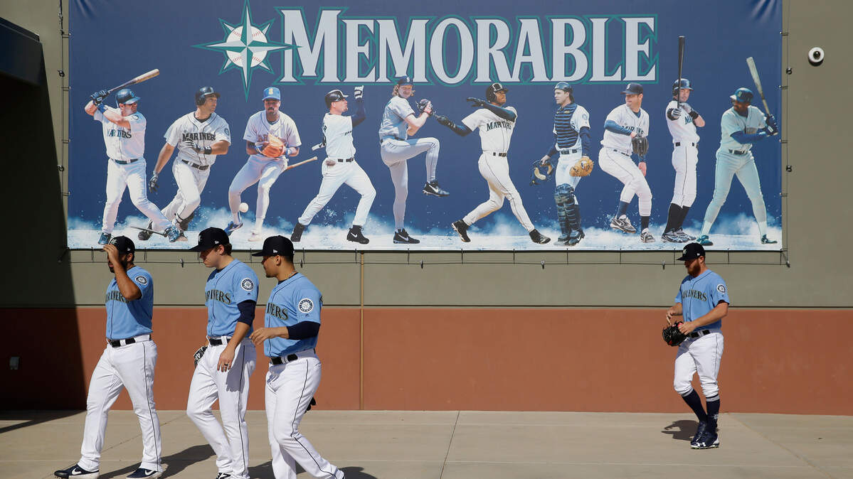 Seattle Mariners players walk to a practice field during spring training baseball practice Tuesday, Feb. 12, 2019, in Peoria, Ariz. (AP Photo/Charlie Riedel)