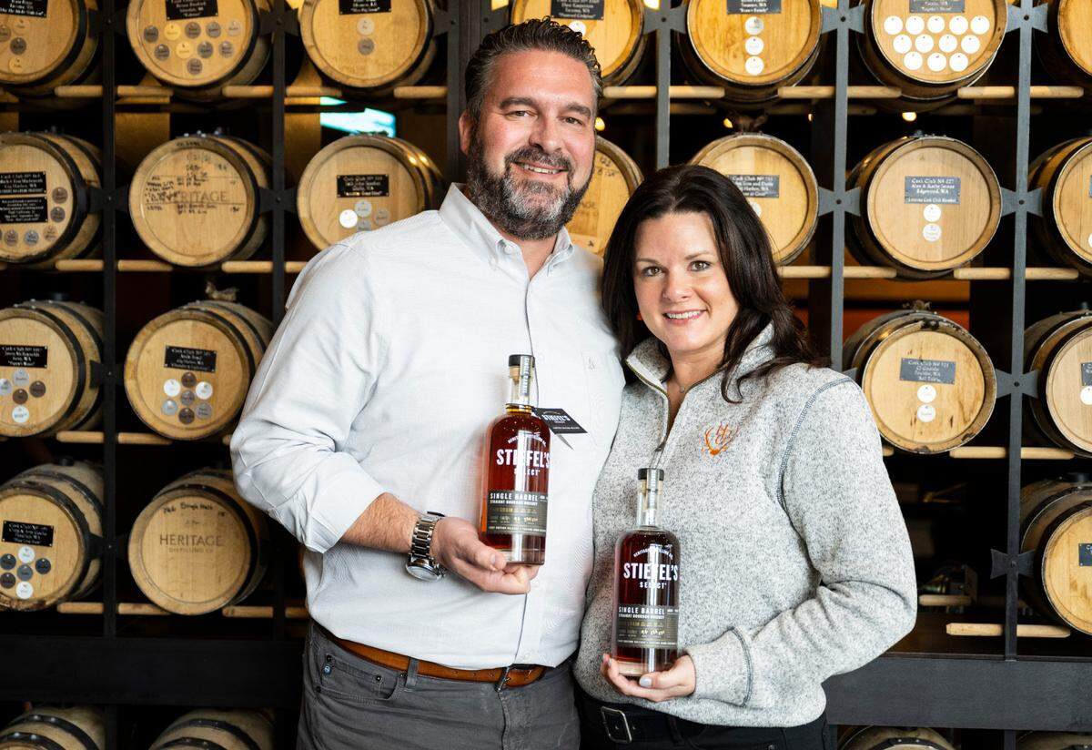 Heritage Distilling Co. founders Justin and Jennifer Stiefel pose for a portrait with bottles of their first line of single-barrel whiskey at Heritage Distilling Co. in Gig Harbor, Wash. on Oct. 26, 2022. 
