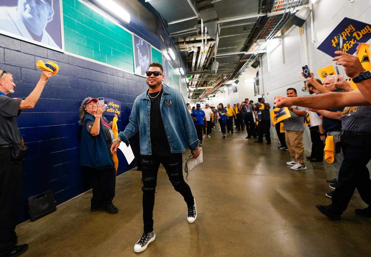 Former Seattle Mariners pitcher Felix Hernandez is greeted by a tunnel of cheering staff as he arrives for a media availability before a baseball game between the Mariners and the Baltimore Orioles, Friday, Aug. 11, 2023, in Seattle. Hernandez will be inducted into the Mariners Hall of Fame on Aug. 12. (AP Photo/Lindsey Wasson)