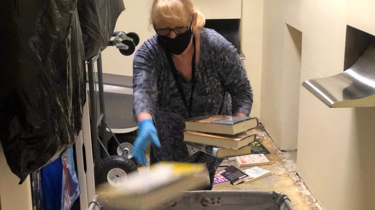 An employee works at the South Hill Pierce County Library recently. Patrons should not sanitize their books when either picking them up or returning them, as the library will be taking precautions.