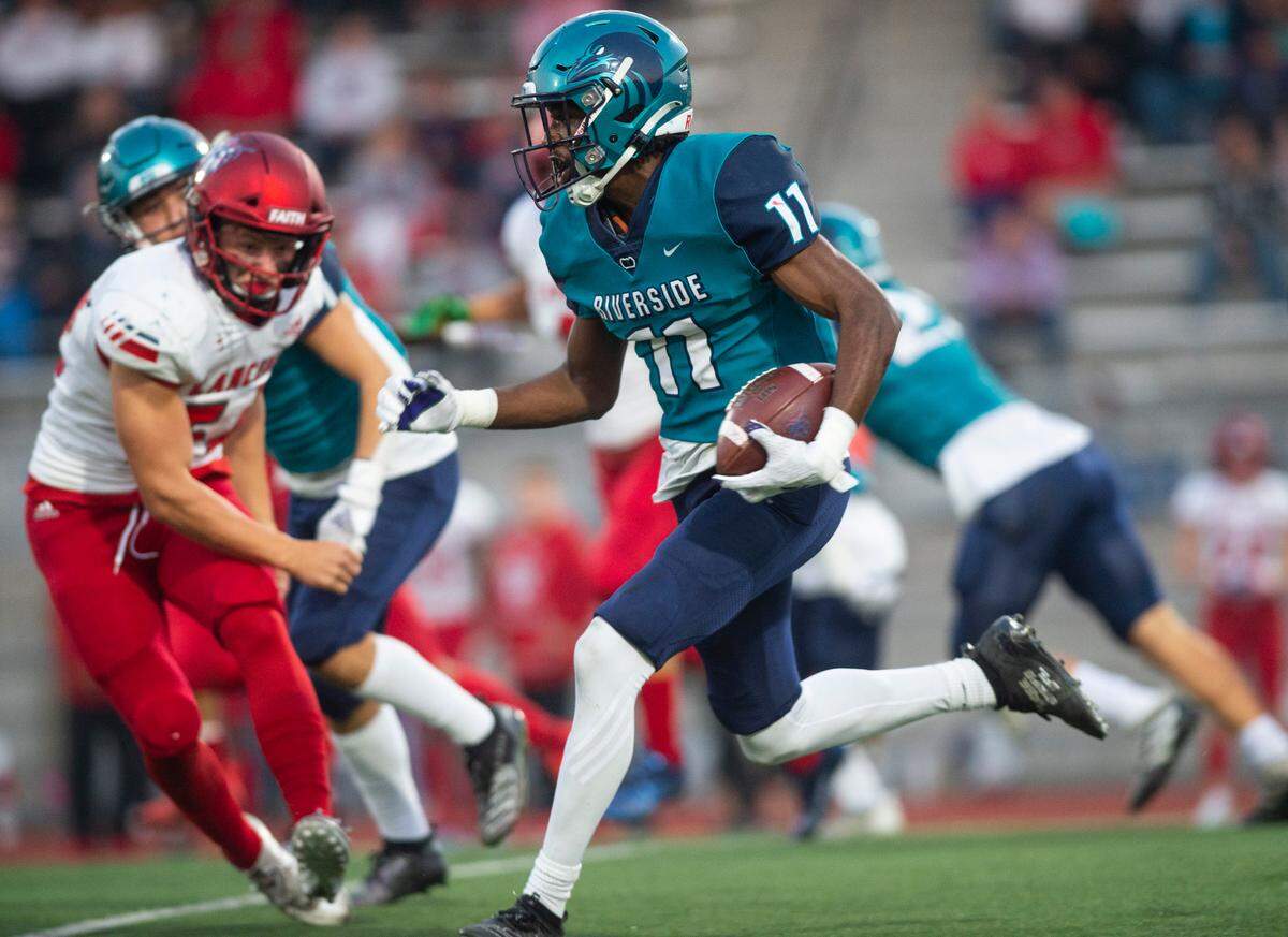 Auburn Riverside wide receiver Carter Rhooms (11) runs down the field with the ball after catching a punt in the first quarter of a game against Kennedy Catholic at Auburn Memorial Stadium in Auburn, Wash. on Oct. 6, 2022.