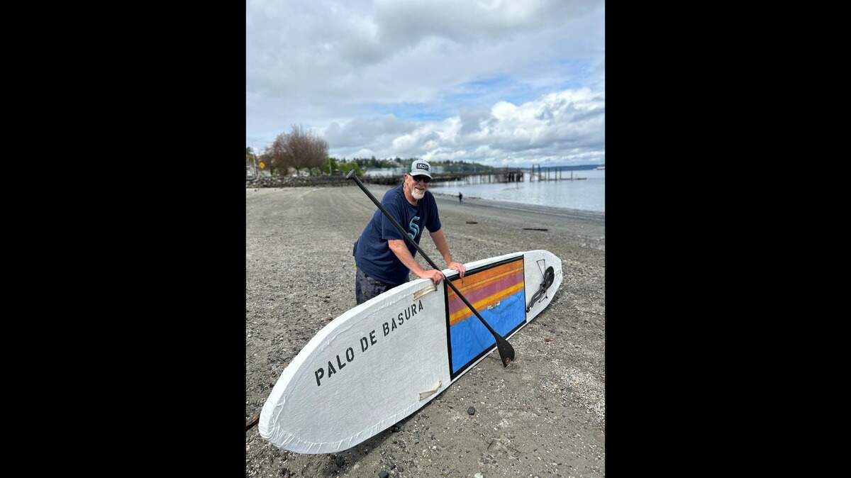 Ken Campbell poses with his homemade paddle board, the “Palo de Basura” — or “garbage stick.” On June 2, Campbell will attempt to paddle from Tacoma to Port Townsend as part of the Seventy48, a race open only to human-powered watercraft. Campbell hopes to raise awareness about plastic pollution in our oceans.