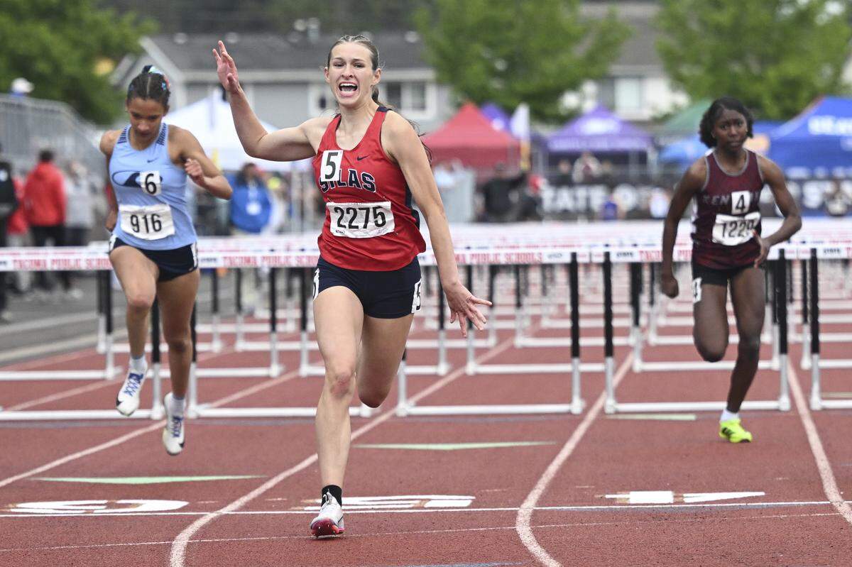 Silas’ Savannah Hinton, center, celebrates as she crosses the finish line for the 3A 100-meter hurdles final during the 2026 State Track & Field Championships on Friday, May 29, 2026, in Tacoma, Wash.