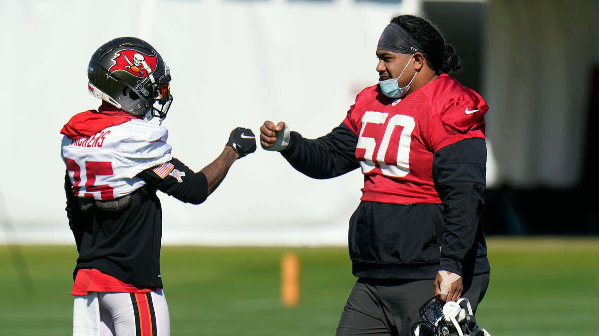 Tampa Bay Buccaneers nose tackle Vita Vea (50) fist bumps wide receiver Jaydon Mickens (85) during a NFL football workout Thursday, Jan. 28, 2021, in Tampa, Fla. The Buccaneers play the Kansas City Chiefs in Super Bowl LV on Feb. 7. (AP Photo/Chris O’Meara)