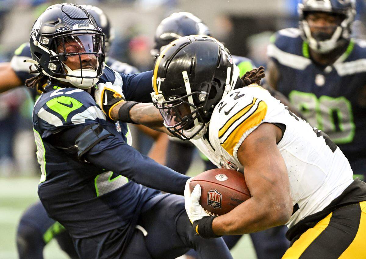 Pittsburgh Steelers running back Najee Harris (22) stiff arms Seattle Seahawks cornerback Riq Woolen (27) during the fourth quarter of the game at Lumen Field, on Sunday, Dec. 31, 2023, in Seattle, Wash.