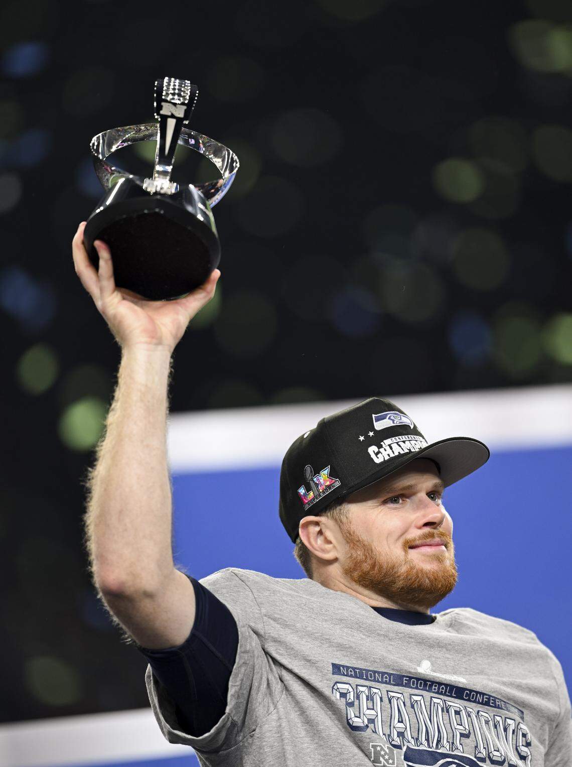 Seattle Seahawks quarterback Sam Darnold (14) holds up the George Halas Trophy after winning the NFC Championship game against the Los Angeles Rams at Lumen Field, on Sunday, Jan. 25, 2026, in Seattle.