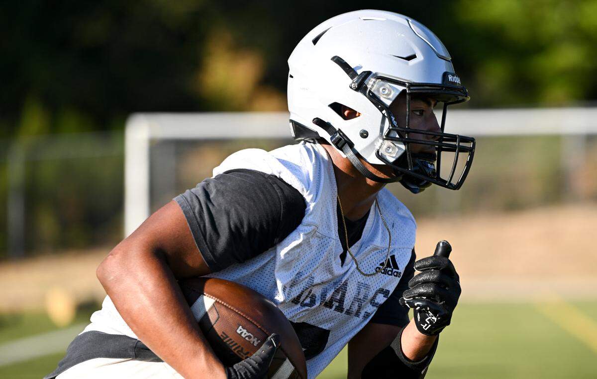 Emerald Ridge running back Navarre Dixon runs a play during a football practice at Emerald Ridge High School, Wednesday, Aug. 16, 2023, in Puyallup, Wash.