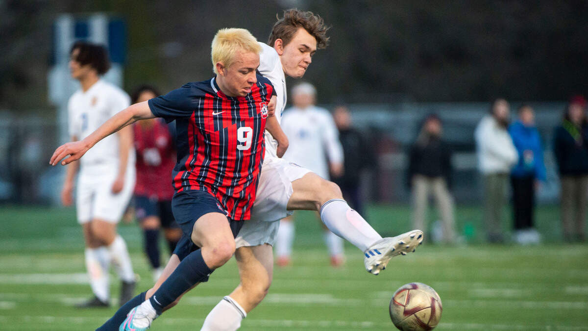 Silas forward Joseph Nichols (9) wrestles with Stadium midfielder Dennis Babarykin (36) as he tries to steal the ball during a 3A Pierce County League game at Silas High School in Tacoma, Wash. on April 11, 2023. Silas won 3-0.