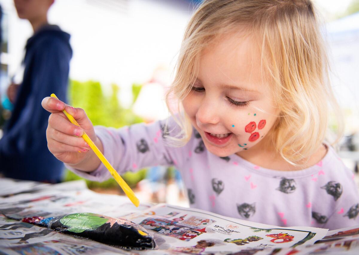 Mila Ellis paints a kokanee salmon in the process of making a fish print at the Donkey Creek Chum Festival at the Harbor History Museum in Gig Harbor, Wash., on Saturday, Nov. 16, 2019.