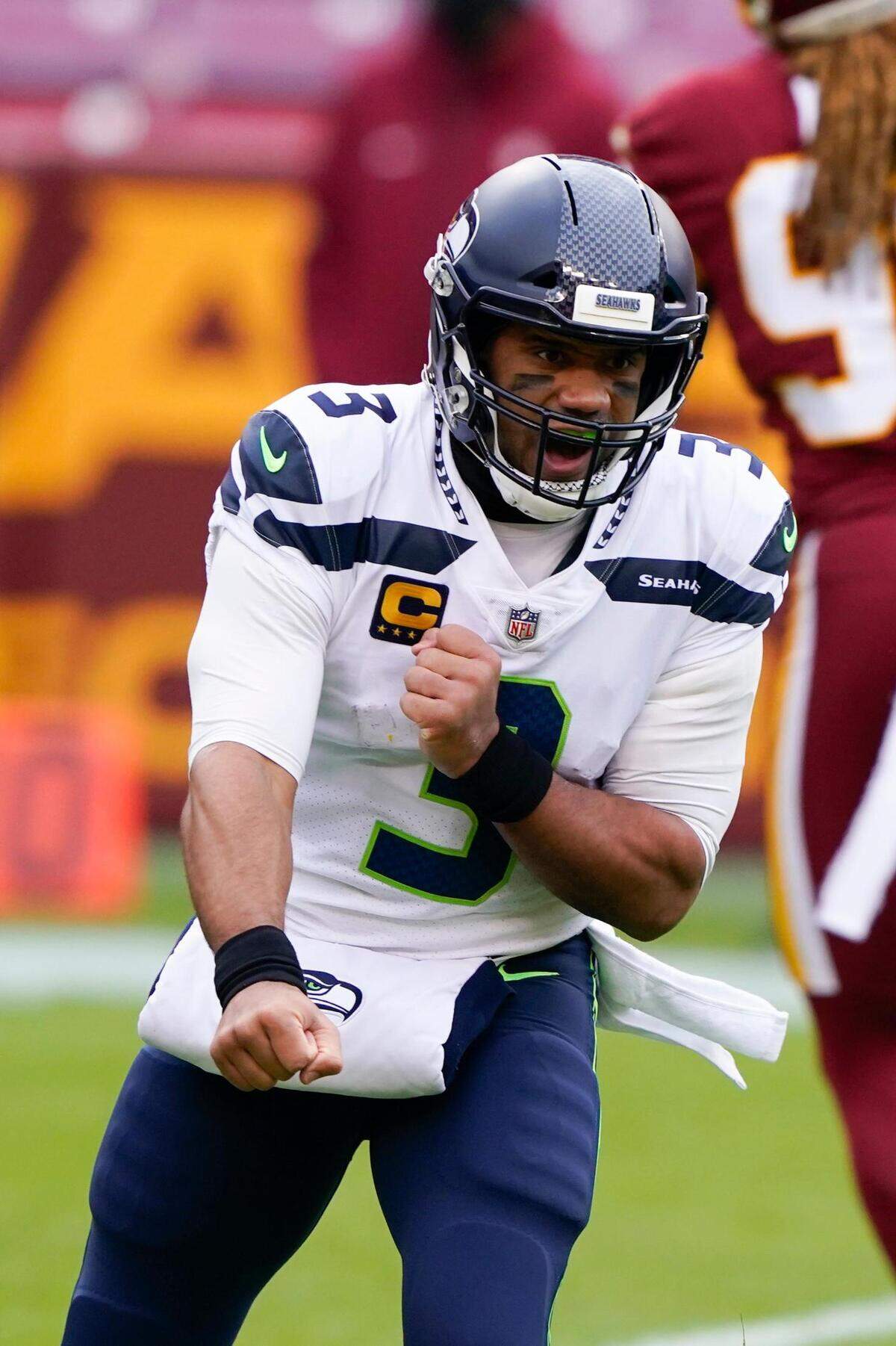 Seattle Seahawks quarterback Russell Wilson (3) celebrating his touchdown pass to tight end Jacob Hollister (86) during the first half of an NFL football game against the Washington Football Team, Sunday, Dec. 20, 2020, in Landover, Md. (AP Photo/Susan Walsh)
