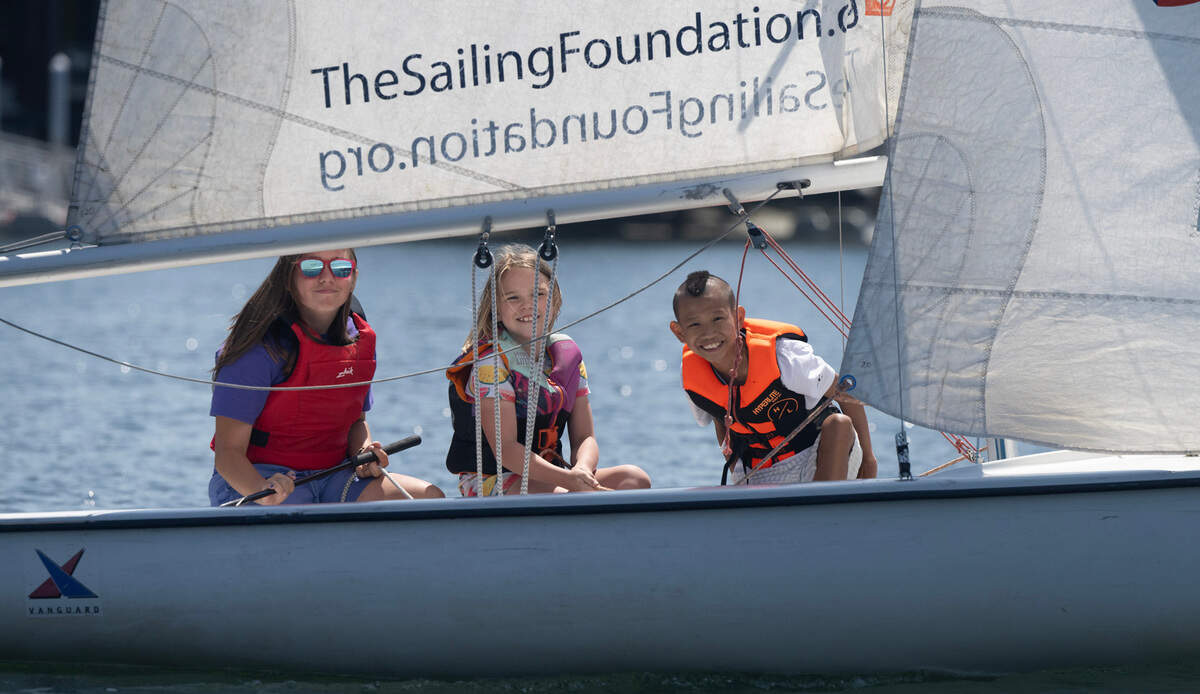 Junior instructor Skylar Smith (left), 13, guides Gig Harbor Junior Sailing Program students Sage Smith, 8, and Michael Jones, 10, as they sail in Gig Harbor, Washington, on Friday, July 26, 2024.