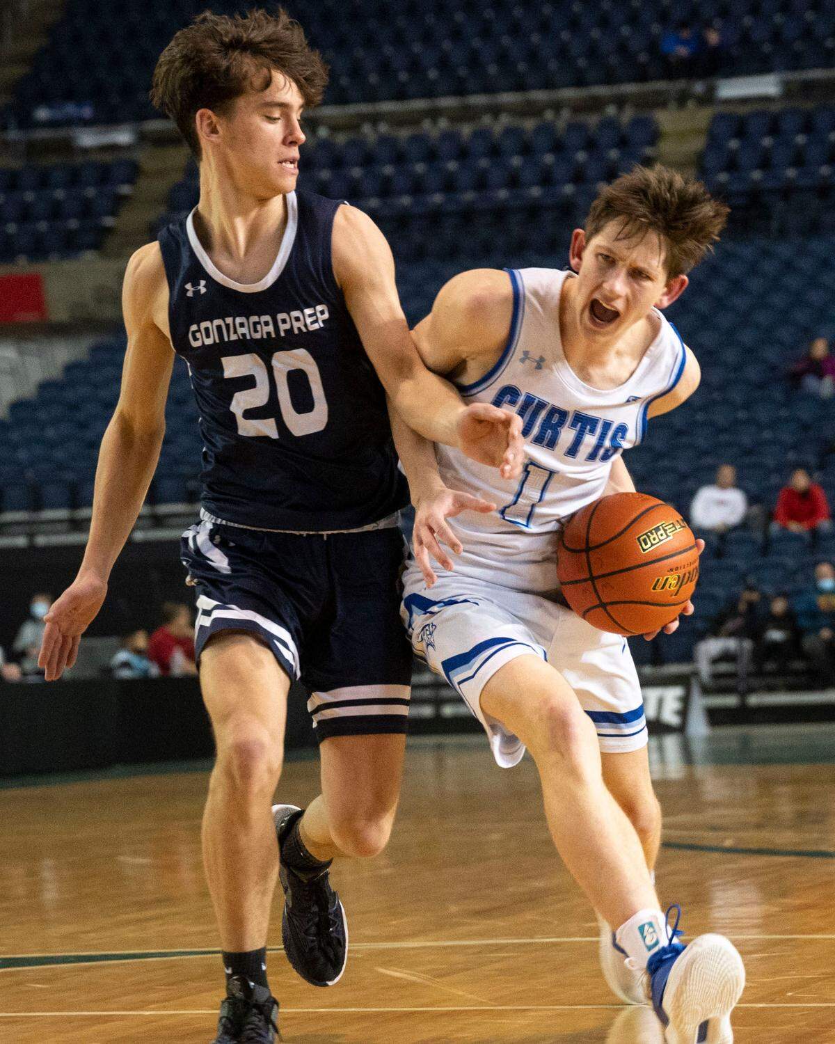 Curtis guard Tyce Paulsen (1) drives to the basket as Gonzaga Prep guard Henry Sandberg (20) defends during the third quarter of a Class 4A quarterfinal state tournament game on Thursday, March 3, 2022, at the Tacoma Dome, in Tacoma, Wash.