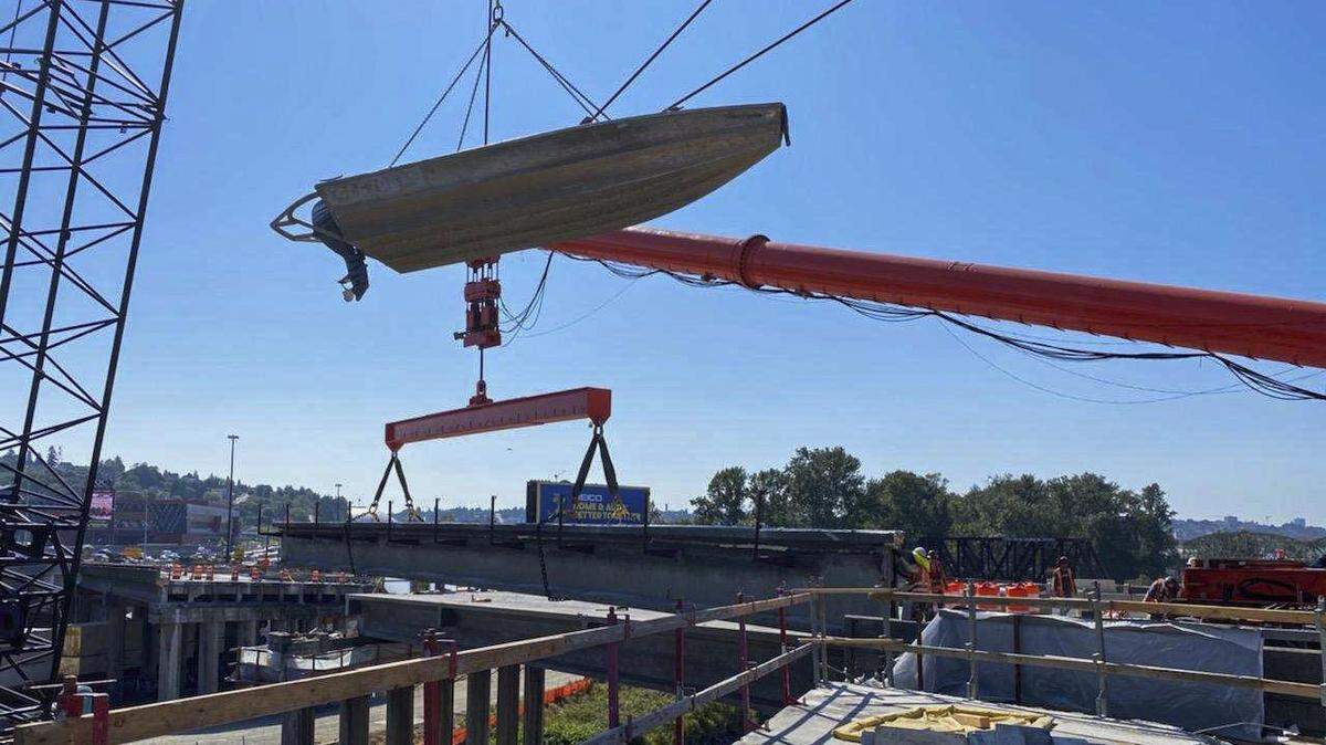 The curious site of a boat suspended in midair by a crane has perplexed some I-5 motorists passing by construction of the new southbound Puyallup River bridge. The boat helps workers install temporary pilings for a platform that is being used to construct the bridge, maintain and update water monitoring systems in the river and provide water rescues if needed. The boat is raised up by the crane when not in use and for safekeeping.