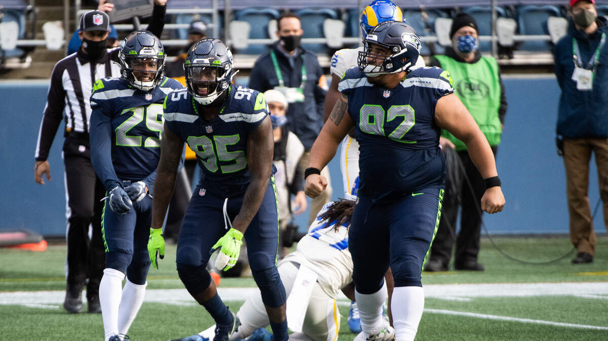 End Benson Mayowa (95) celebrates a tackle with Seahawks defensive linemate Bryan Mone during Seattle’s home win over the Los Angeles Rams at Lumen Field on Dec. 27, 2020.