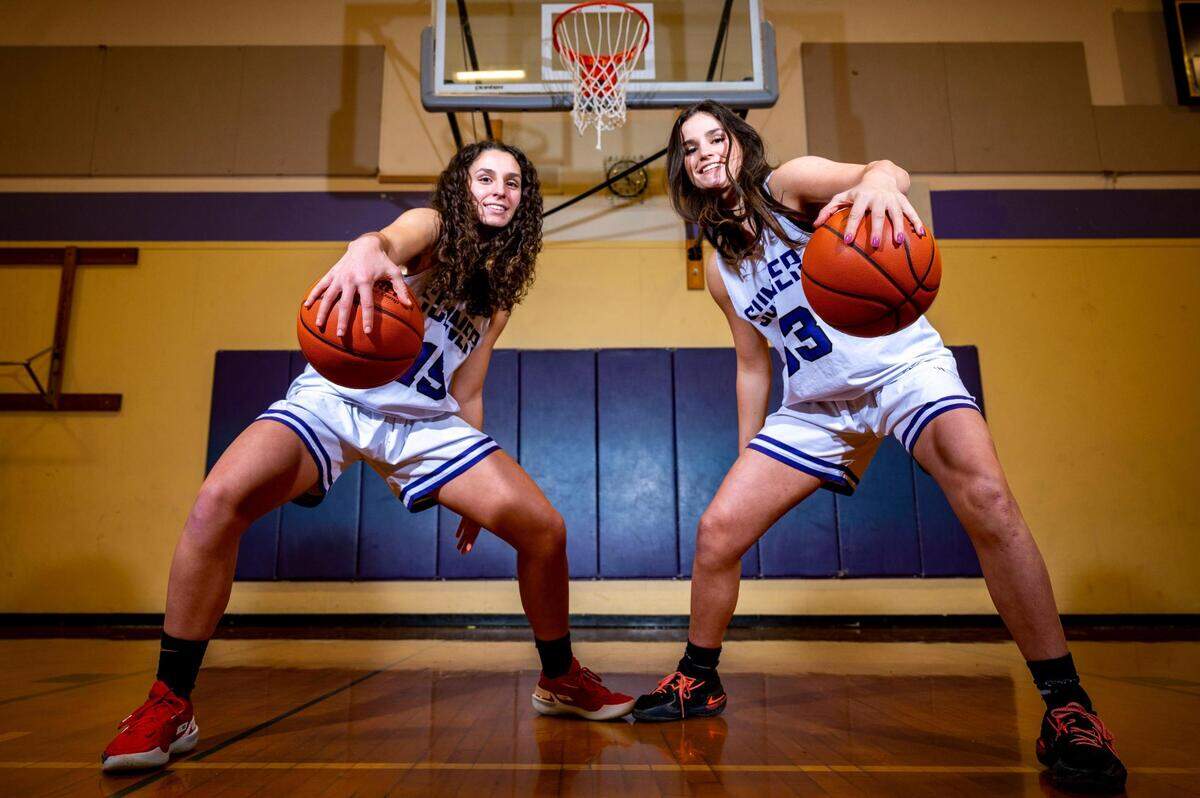 Catelyn Deaver (left), and her twin sister, Alyson, who play both guard and forward at Sumner High School, pose for a portrait on at the school on Thursday, Jan. 13, 2022, in Sumner.