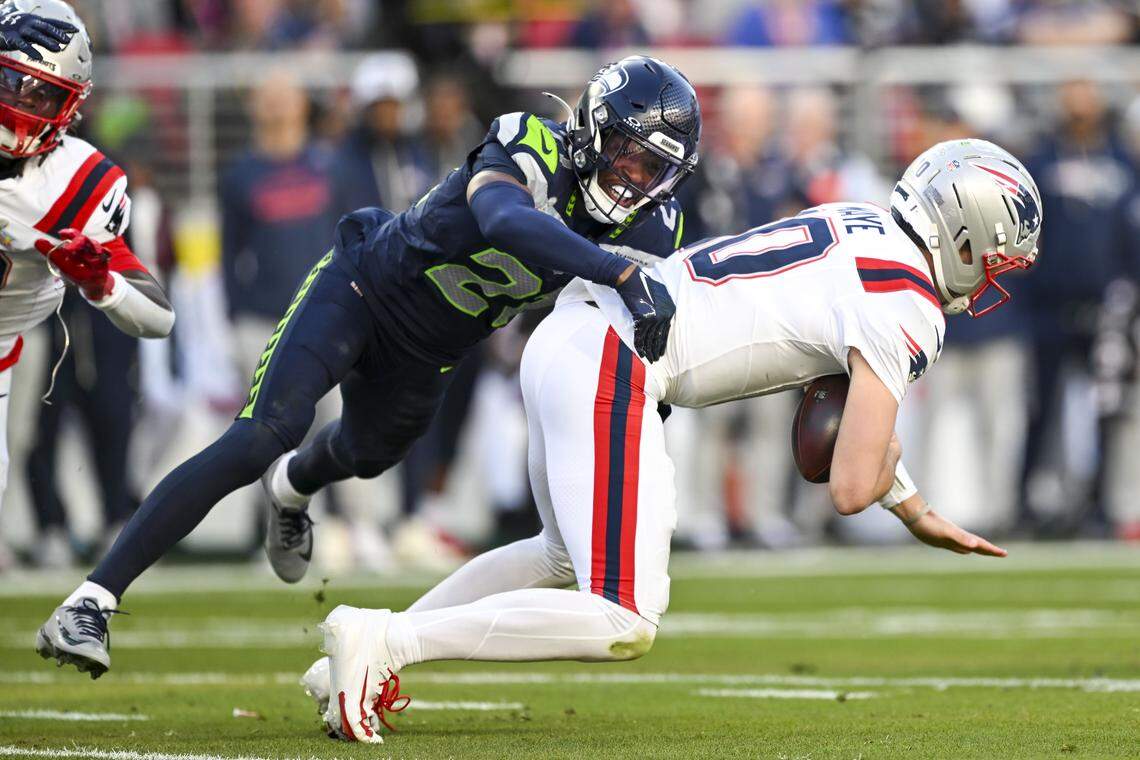 Seattle Seahawks cornerback Devon Witherspoon (21) tackles New England Patriots quarterback Drake Maye (10) during the first quarter of Super Bowl LX at Levi's Stadium on Feb. 8, 2026 in Santa Clara, Calif.