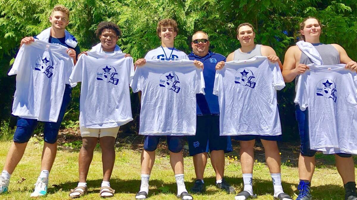 From left, Gig Harbor High School linemen Samuel Peacock, Malik Livingston, Jake Flynn, coach Ti Zurfluh, Brendon Rivera and Nick Belarde.