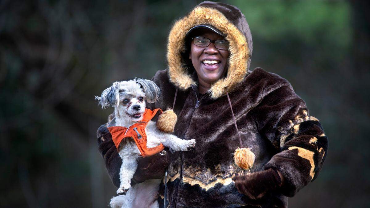 FILE PHOTO: Joy Broadnax of Lakewood bundles up against the chilly wind as she takes her dog, Bentley, to play at frigid Wapato Park in Tacoma, Washington, on Tuesday, Feb. 22, 2022.