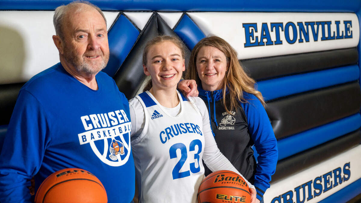 Eatonville sophomore guard Bailey Andersen is flanked by her grandfather, Dan Fountain, and her mother, Deanna Andersen, as they pose for a portrait at Eatonville High School on Wednesday, Jan. 25, 2023, in Eatonville, Wash. Deanna is in her first year as head coach of the girls team this season and is getting assistance on the bench from her father, Dan, who was the boys coach at Eatonville for 16 years.