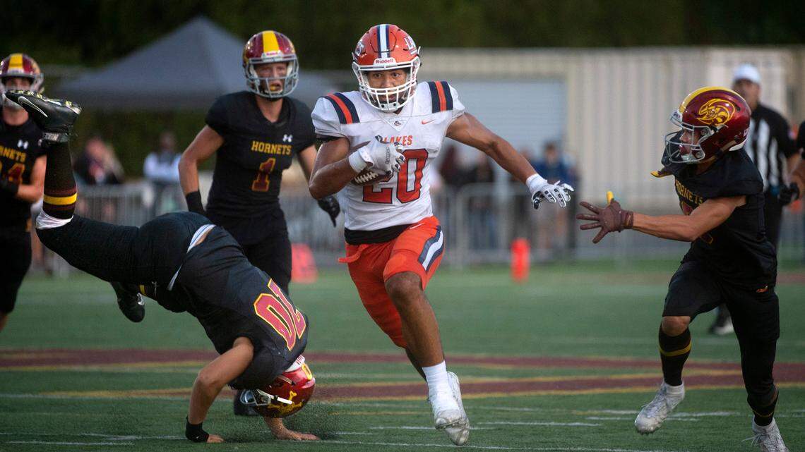 Lakes running back Leo Pulalasi breaks away from Enumclaw defenders Nicholas Rainwater (70), Clive Pond (1) and Do Bods during Thursday night’s non-league football game at Enumclaw Stadium at Pete’s Pool in Enumclaw, Washington, Sept. 9, 2021.