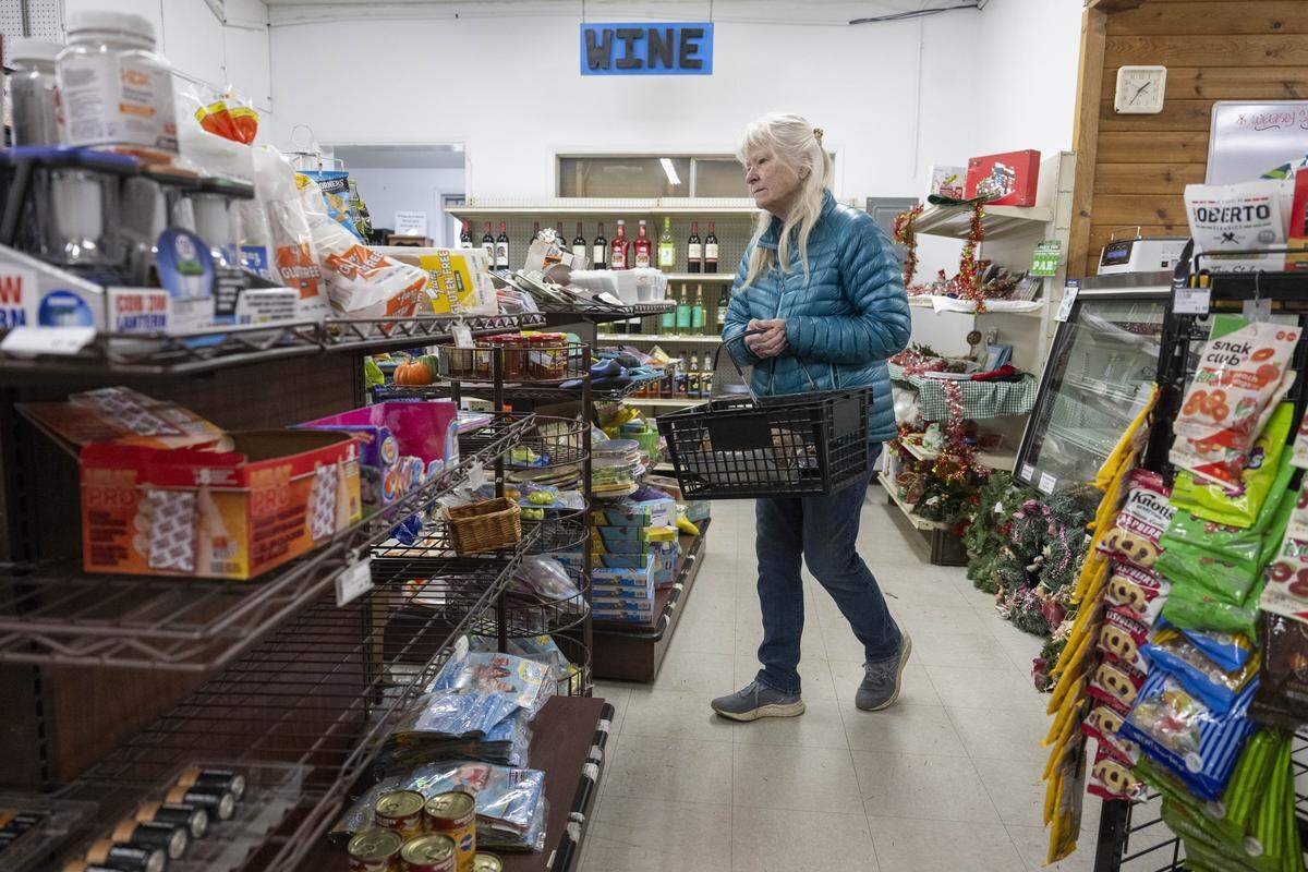 Kelly Hinds, a 38-year resident of Anderson Island, walks the aisles of the Anderson Island General Store on its closing day on Monday, Feb. 2, 2026, in Anderson Island, Wash.