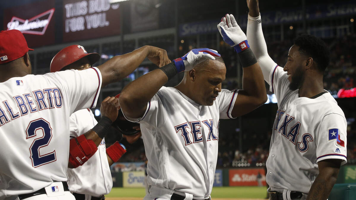 Texas Rangers Adrian Beltre, center, is congratulated by Hanser Alberto (2) and Jurickson Profar, after hitting a three-run home run against the Seattle Mariners during the first inning of a baseball game Friday, Sept. 21, 2018, in Arlington, Texas. (AP Photo/Mike Stone)