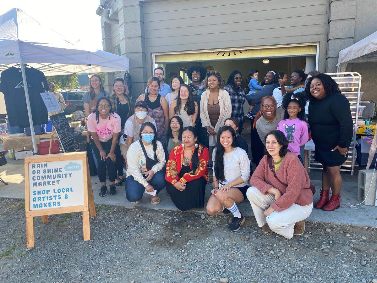People gather for a photo at the “Rain or Shine” community artisan and maker market event on Oct. 2, 2022, at Parable.