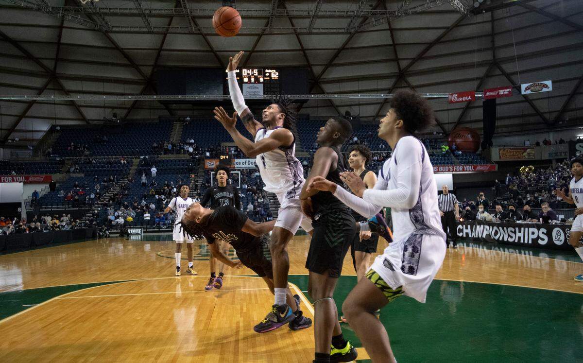 Auburn’s Dae’Kwon Watson draws a charge on Garfield’s Raphiel Justice in the waning seconds of overtime to preserve the Bulldogs’ 64-60 victory in Thursday morning’s quarterfinal game of the WIAA 3A Boys Basketball State Championships tournament in the Tacoma Dome in Tacoma, Washington, on Thursday, March 3, 2022.