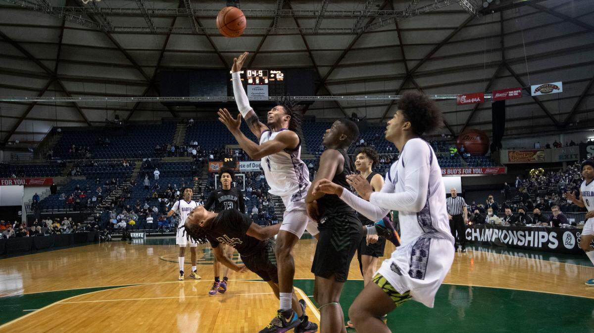 Auburn’s Dae’Kwon Watson draws a charge on Garfield’s Raphiel Justice in the waning seconds of overtime to preserve the Bulldogs’ 64-60 victory in Thursday morning’s quarterfinal game of the WIAA 3A Boys Basketball State Championships tournament in the Tacoma Dome in Tacoma, Washington, on Thursday, March 3, 2022.