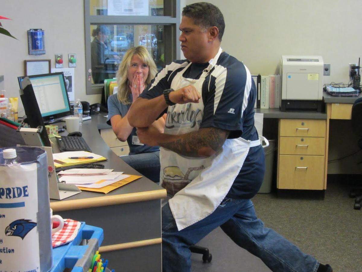 Paul Fu’a, right, warming up and stretching prior to a rootbeer float team run with secretary Heather Bedwell, left, on April 2015.