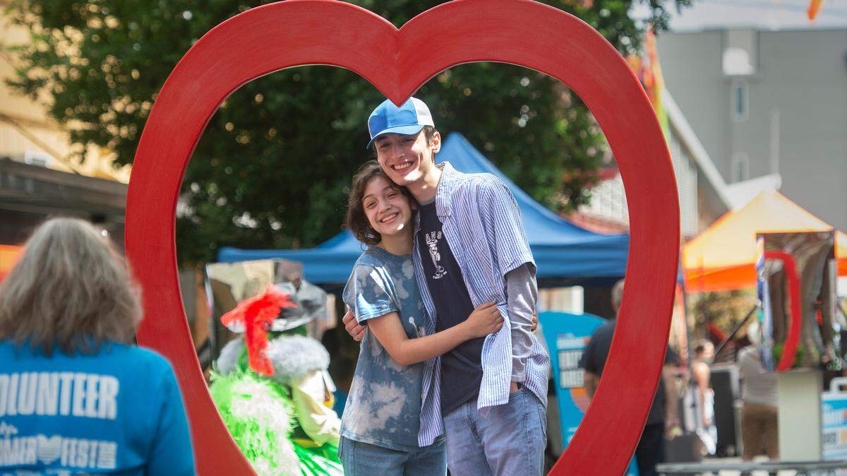Taina Johnson (left) and Ethan Timmons, both of Olympia, get a photo taken during the inaugural LoveOly Summer Fest in downtown Olympia July 17.