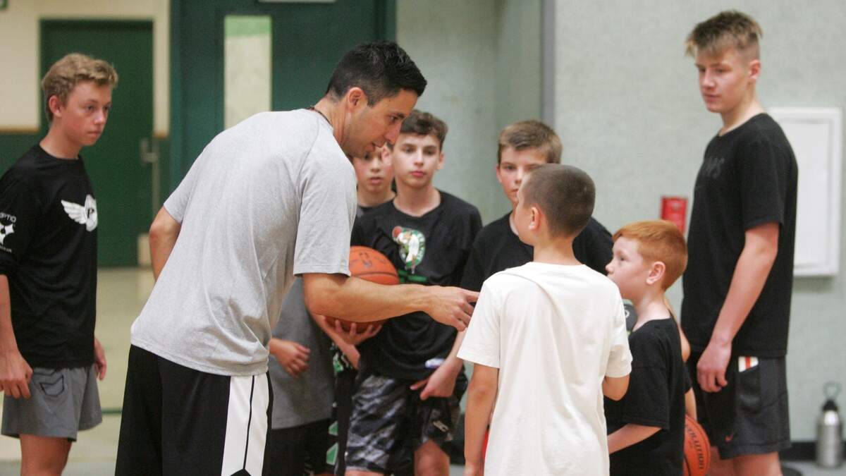 Peninsula coach Matt Robles talks with campers during Peninsula’s boys basketball summer camp.