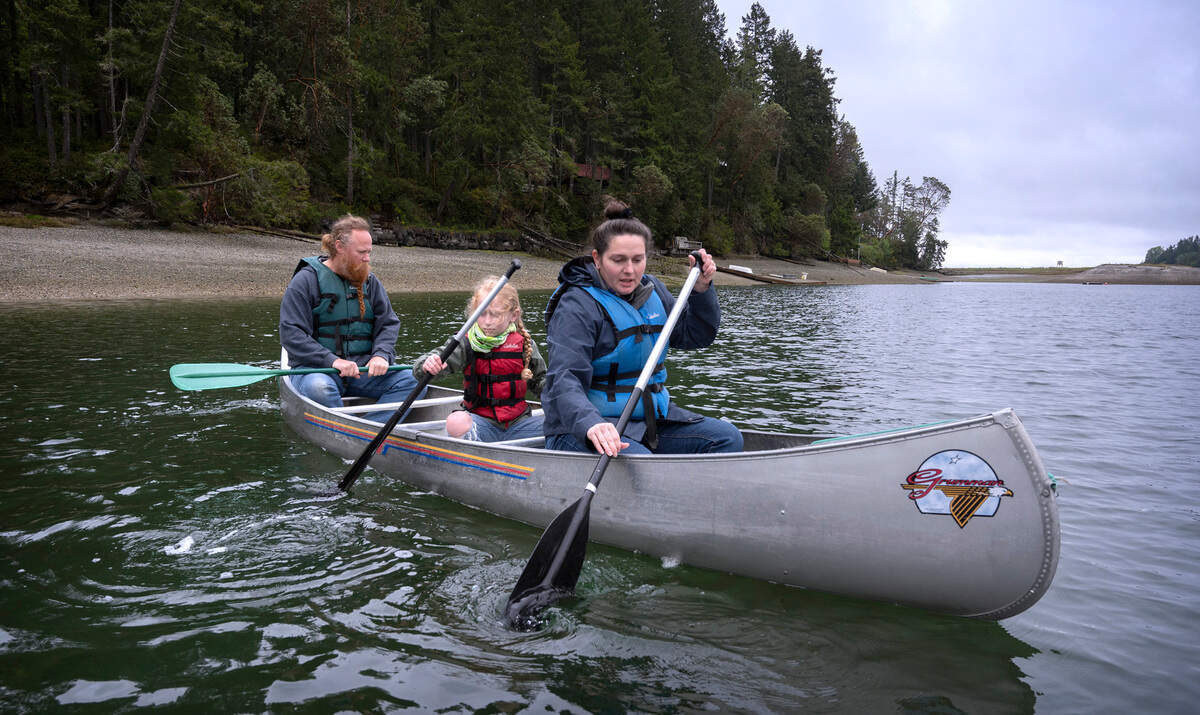 Austin Satterla (from left), Leo O’Callaghan and Kieran O’Callaghan paddle through Glen Cove during the Camp Corral military family weekend at YMCA Camp Seymour on the Key Peninsula on Saturday, May 14, 2022.