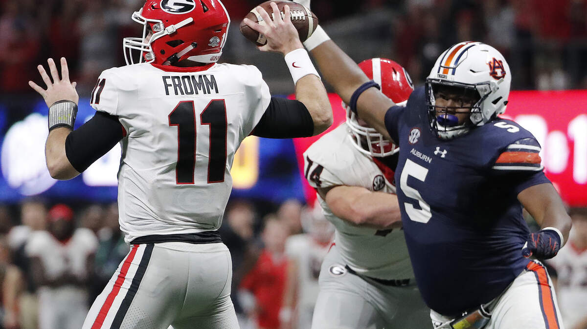 FILE - In this Dec. 2, 2017, file photo, Georgia quarterback Jake Fromm (11) looks to throw a pass as Auburn defensive lineman Derrick Brown (5) pressures during the second half of the Southeastern Conference championship NCAA college football game in Atlanta. Auburn and Georgia meet Nov. 10 in a rematch from last year’s SEC title game. (AP Photo/David Goldman, File)
