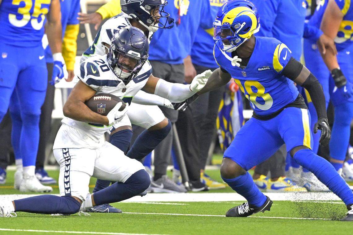 Jan 5, 2025; Inglewood, California, USA; Seattle Seahawks safety Julian Love (20) is stopped by Los Angeles Rams wide receiver Tyler Johnson (18) after an interception in the first half at SoFi Stadium. Mandatory Credit: Jayne Kamin-Oncea-Imagn Images